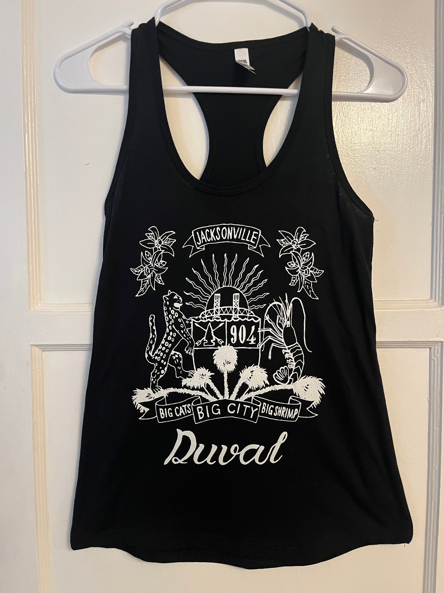 Duval Crest..... Join the Fam!  Show your 904 love at any GAME OR ANY EVENT with this epic ladies racer tank.  Soft Cotton, Ladies cut tanks  in Black or Charcoal in sizes XS, S, M, L, XL, and XXL  Glow in the dark lettering  Locally Made in Jax