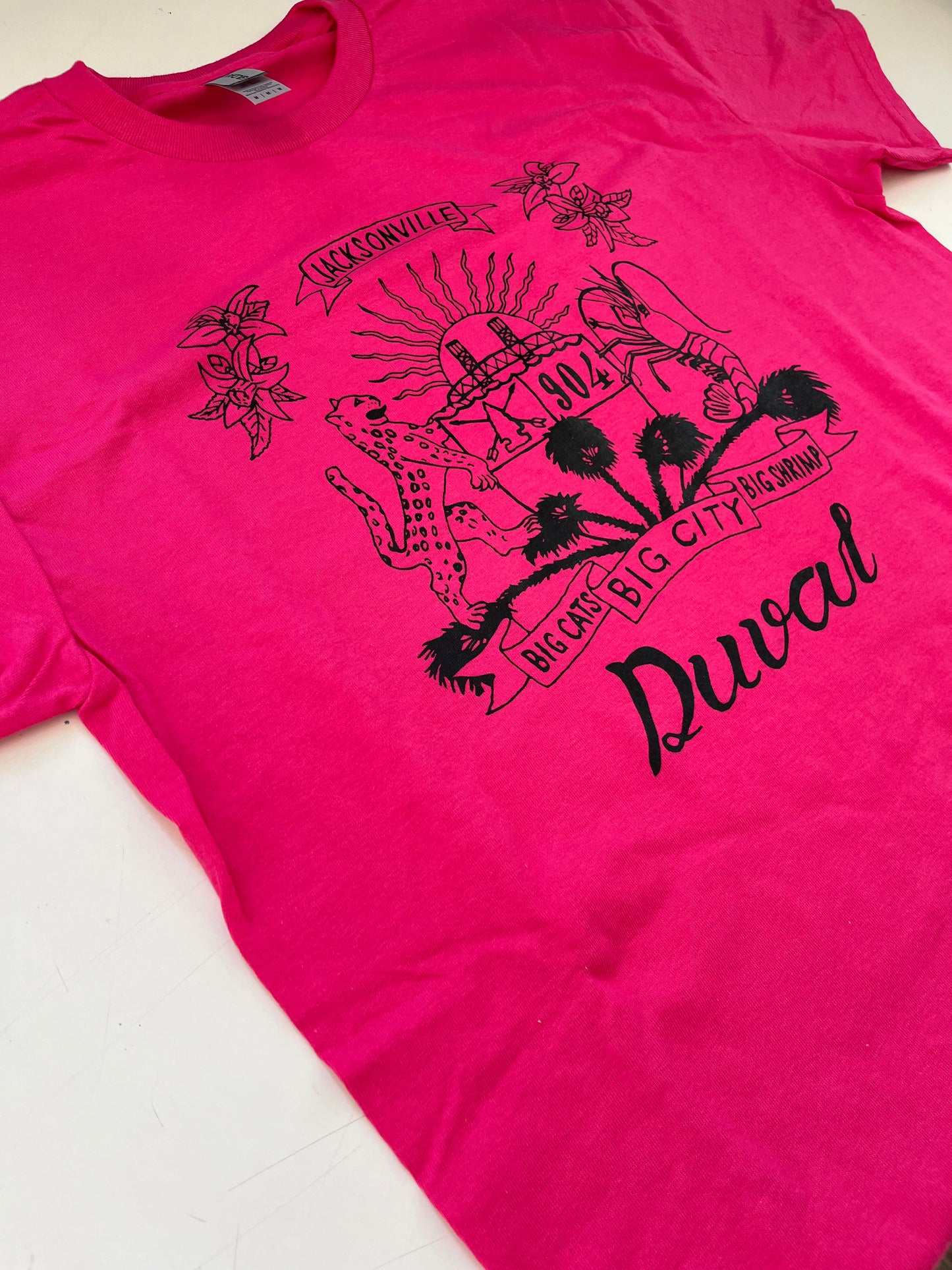 Duval Crest..... Join the Fam! Show your 904 love with this classic tee.  Locally made t-shirts with glow in the dark (white) or black lettering  Available in sizes S, M, L, XL, XXL, 3XL, and 4XL.   Hot Pink Tee with Black  Lettering