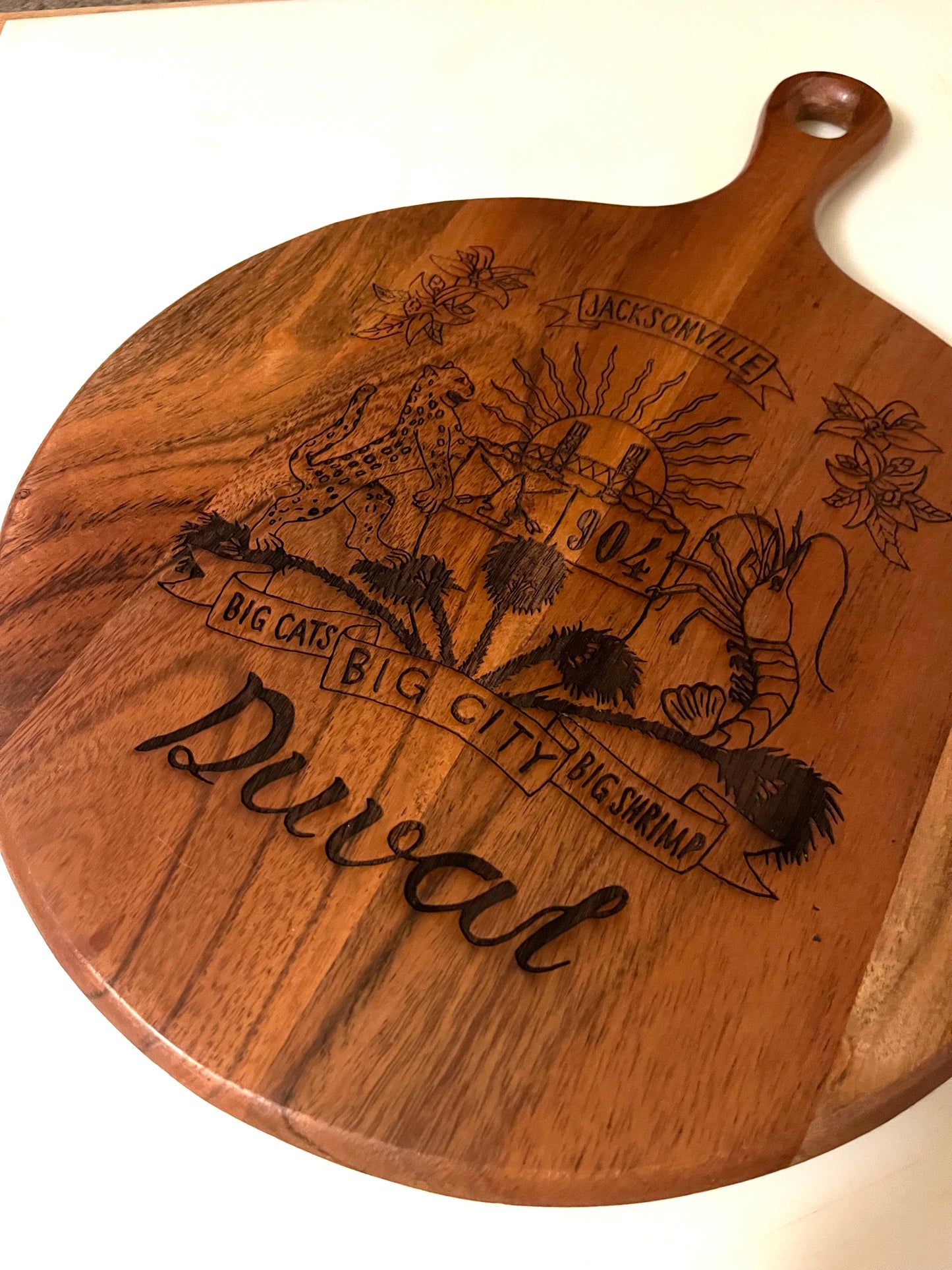 Duval Crest..... Join the Fam!&nbsp;  Show your 904 love at home or at any event with this  Wooden engraved charcuterie board.&nbsp;  10" diameter 3/4' diameter